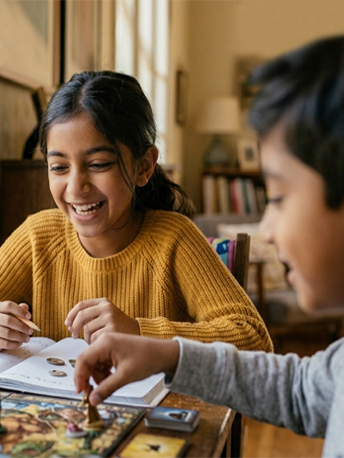 South Asian or East Asian child, age 8–10, at a school desk, warm afternoon light.